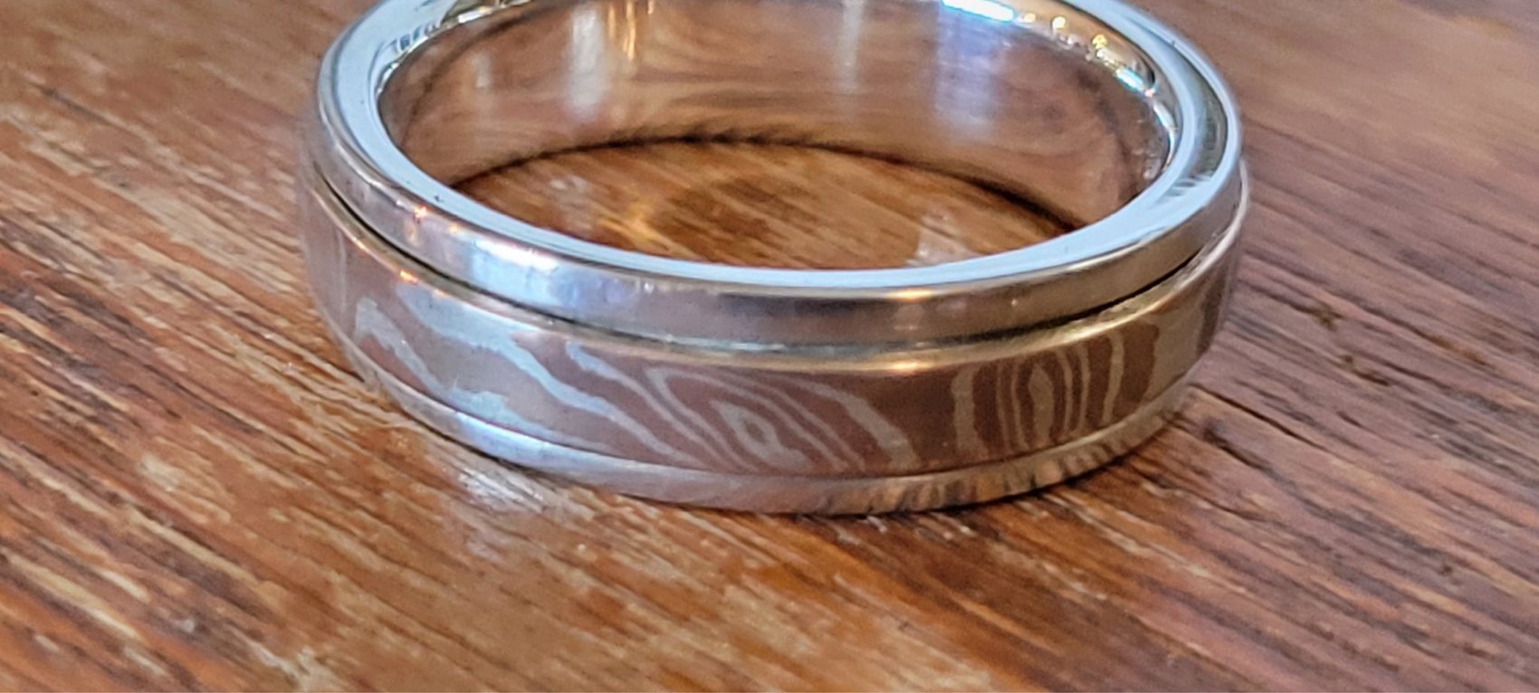 Mokume gane band ring with layered copper and silver wood-grain pattern